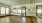 a room with a wood floor and glass walls