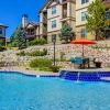 a pool with chairs and umbrellas by a building